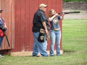 Instructor teaching a young woman how to shoot a firearm