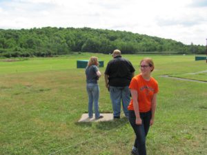 Shooting sports woman and student discussing matters at a range